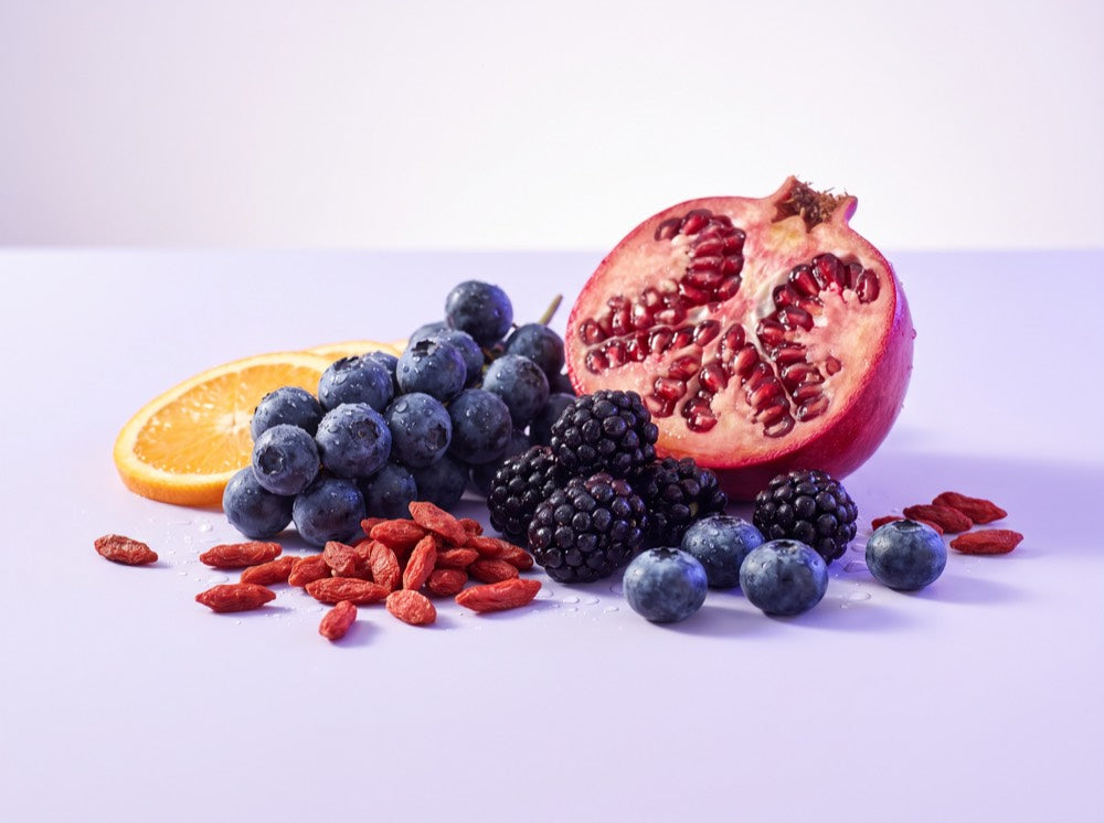 Blueberries, blackberries, pomegranate, goji berries and orange arranged as an antioxidant blend
