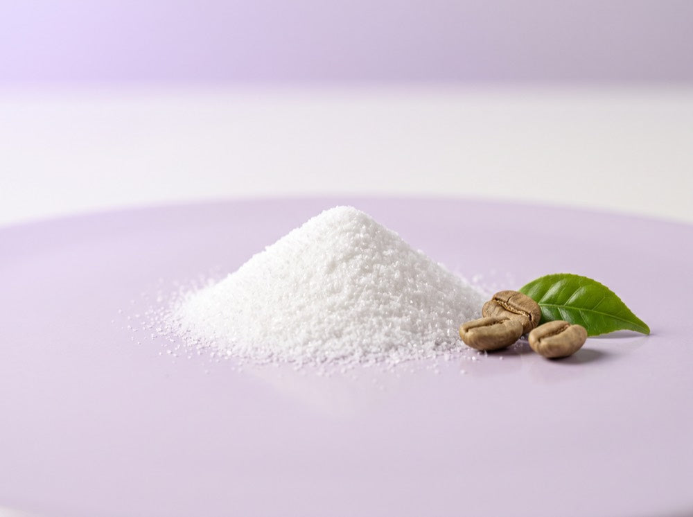 Caffeine, shown as fine white crystalline powder with green coffee beans and a tea leaf